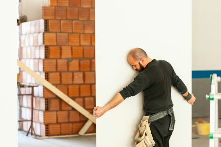 Worker builds a plasterboard wall.